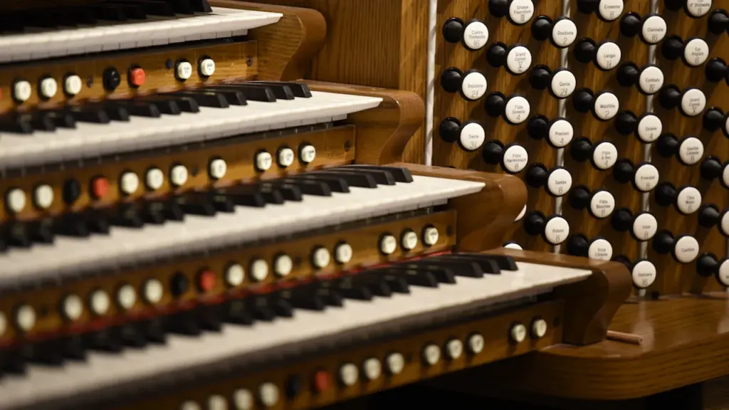 Detailaufnahme einer klassischen Orgel mit vielen Tasten und zahlreichen runden Registern.
