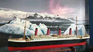 Detailreiches Modell der Titanic vor einer dramatischen Eisberg-Kulisse in der Ausstellung.